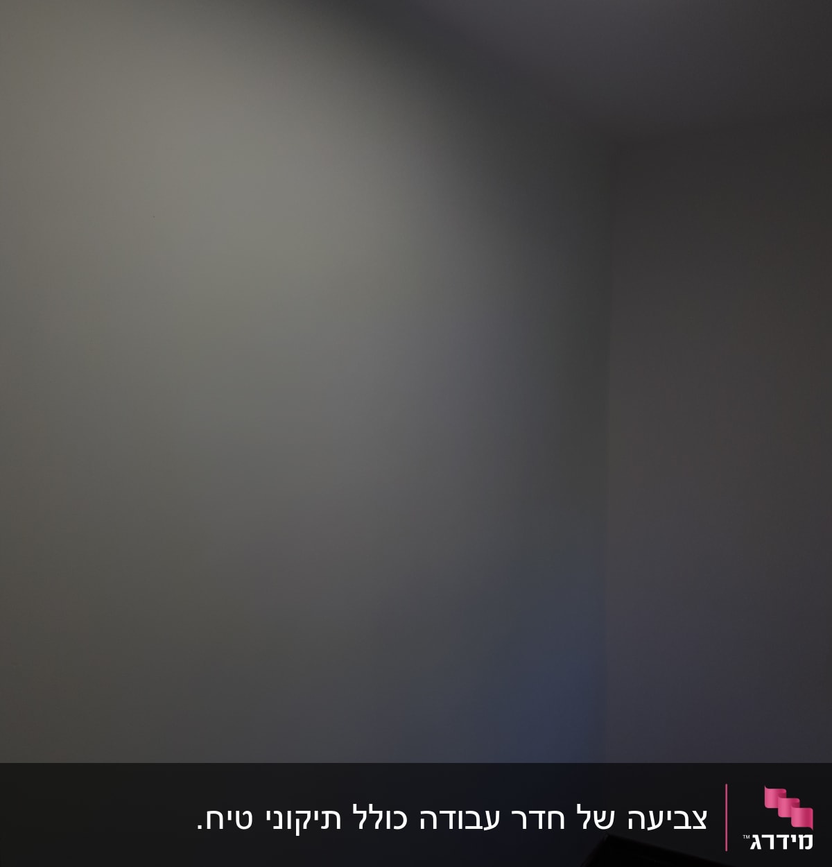 קיר צבוע בגוון אפור בהיר עם תאורה עליונה